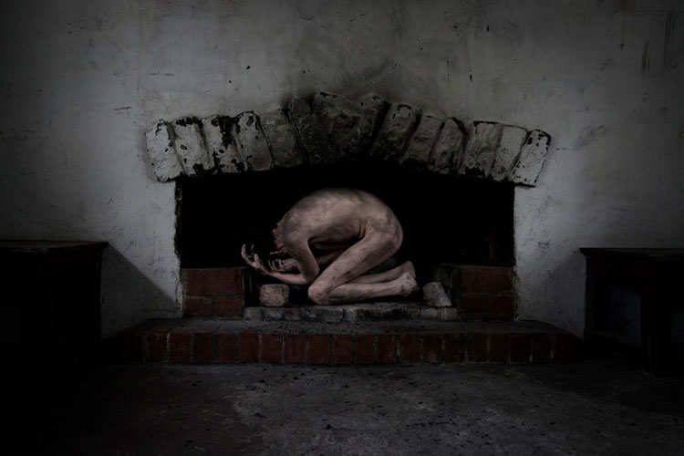 naked skeletal figure crouching in a fire place.