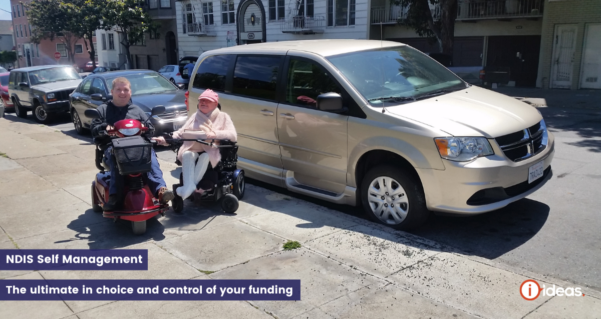 A couple infront of an accesible vehicle in San Fransisco, they are both seated, Carolyn in a wheelchair, Steve in an motorised scooter 