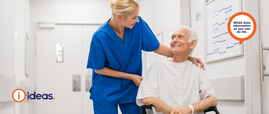 An elderly person in a wheelchair being pushed by a nurse in a hospital.