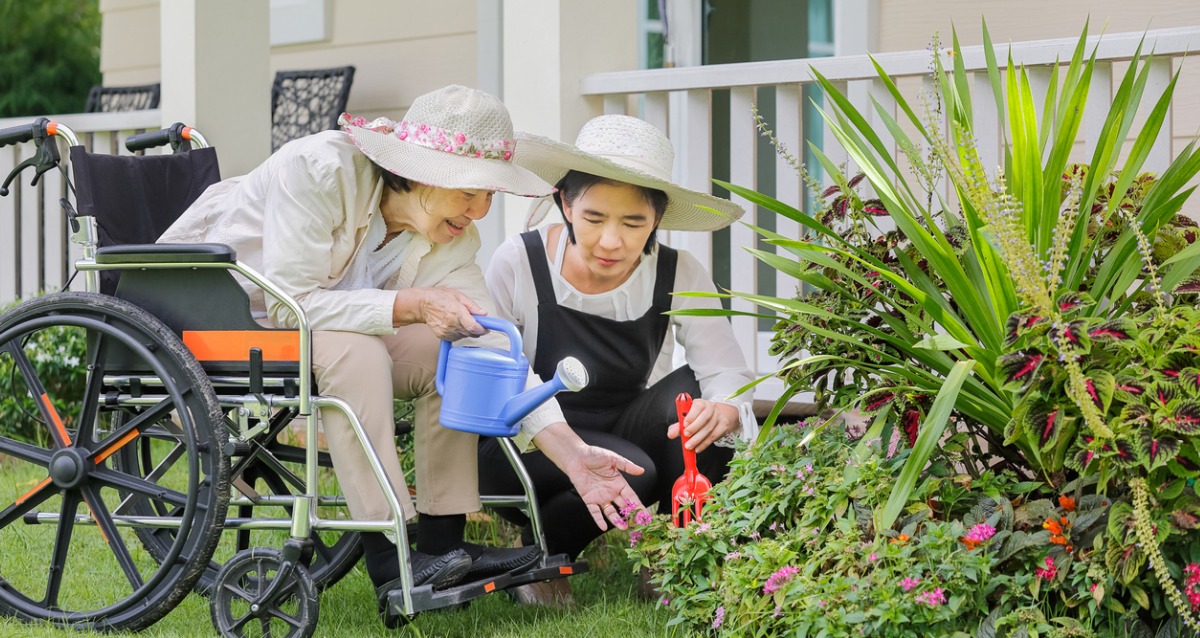 Elderly woman gardening in backyard with daughter 