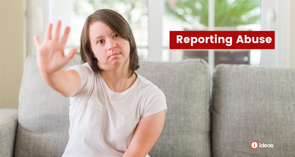 Reporting Abuse - Woman sitting on a couch with her hand up to indicate stop. She has Down Syndrome.