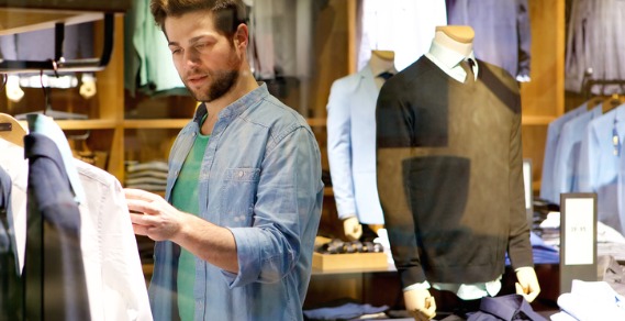 Young man looking at shirts in a shop