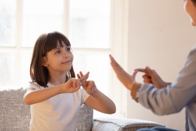 young girl and woman using sign language to communicate