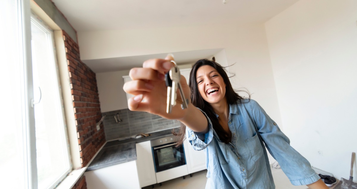 A young lady holding a set of house keys