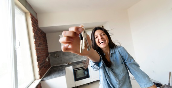 A young lady holding a set of house keys