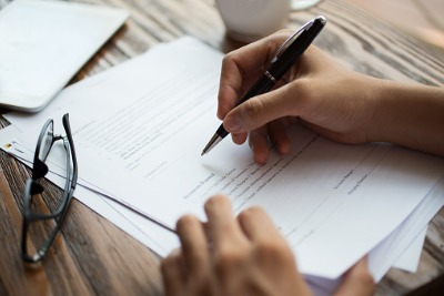 Image of businessman's hand writing on paper