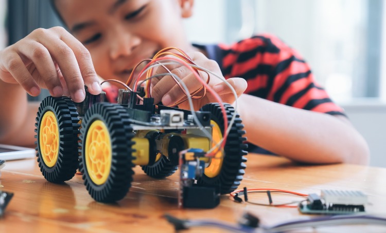 concentrated boy creating robot at lab picture