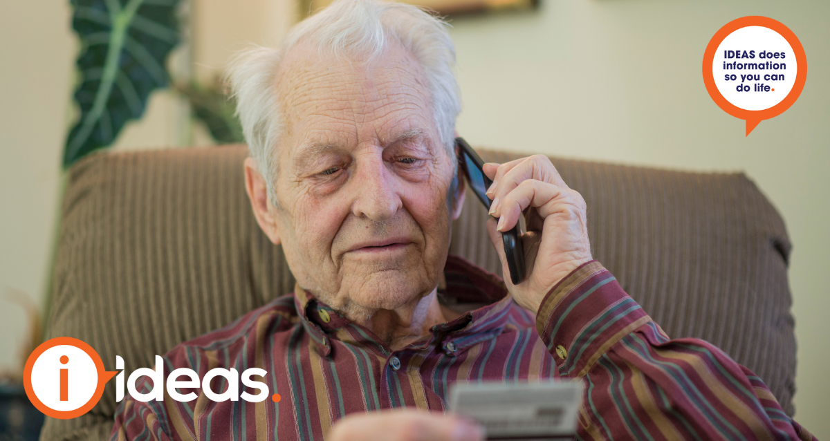 Elderly man on phone call holding credit card in hand