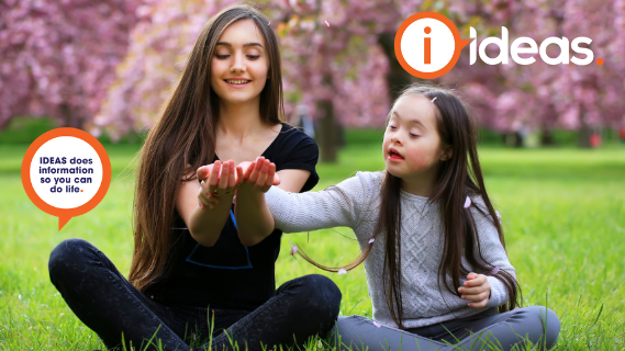 Young girl and teenage girl sitting in grass