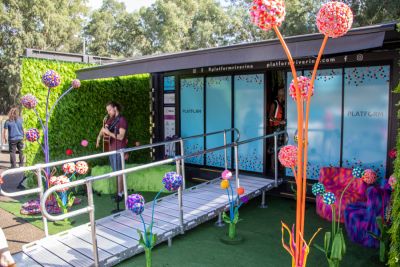 Exterior shot of PLATFORM art installation space with brightly coloured three dimensional organic shaped works with long tendrils and fuzzy balls by artist Bliss Cavanagh