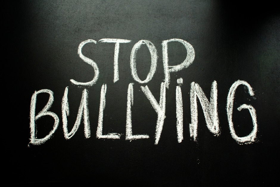 Handwritten text on a blackboard reads "STOP BULLYING"