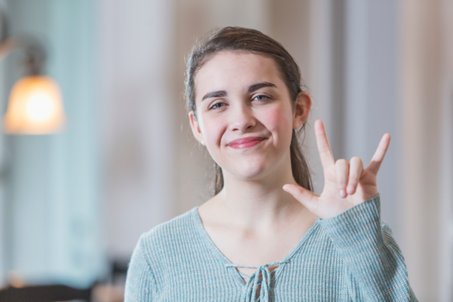 Smiling girl doing hand signal 