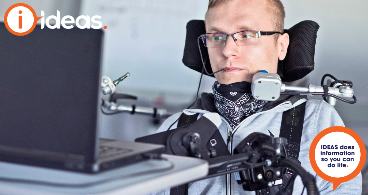 A man with assistive technology is using a laptop.