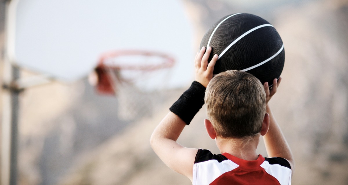 A young boy lining up a basketball shot