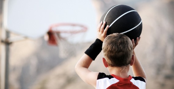 A young boy lining up a basketball shot