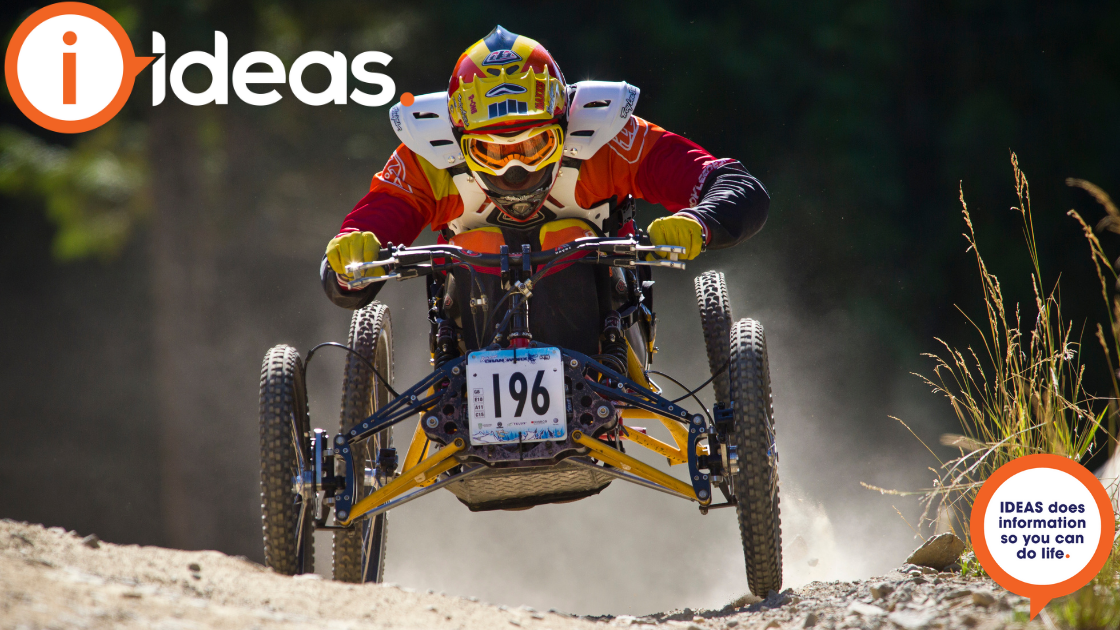 Image of person with disability riding an adaptive mountain bike fast down a dirt trail.