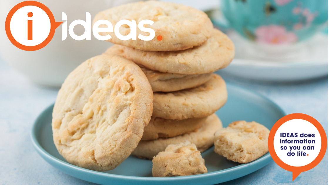 Some plain biscuits stacked on a blue plate, a teacup is in the background.