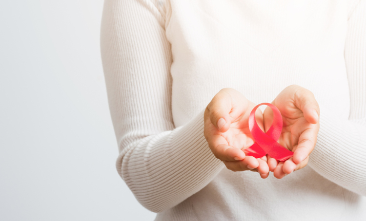 Breast cancer awareness healthcare and medicine concept. Close up Asian woman holding pink breast cancer awareness ribbon on hands treatment charity, studio shot isolated on white background (Breast cancer awareness healthcare and medicine concept. Cl