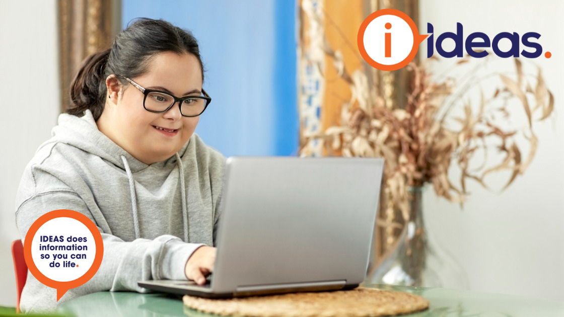 A girl with glasses and dark hair with intellectual disability is using a laptop computer.