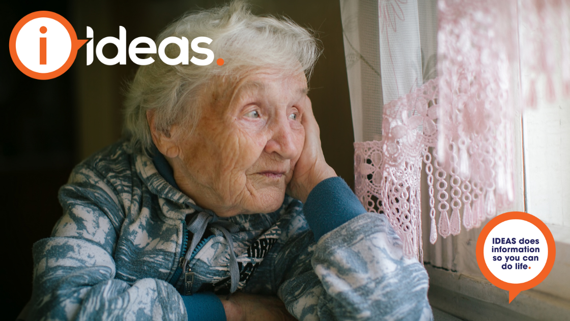 Elderly woman looking out of a window