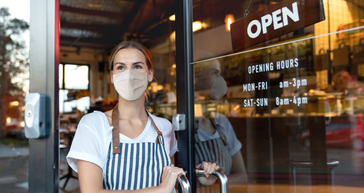 Waitress wearing a mask outside a cafe