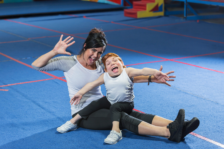 A young woman with disability and her Gymnastics instructor and playing up to the camera