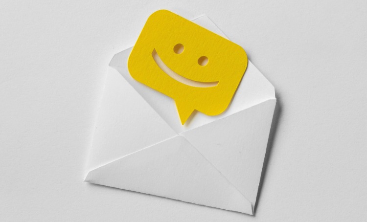 Happy mail. A white envelope with a smiley face coming out