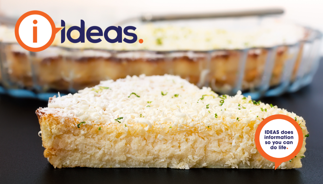 A slice of pale yellow pie dusted with white icing sugar and with lime zest on top.