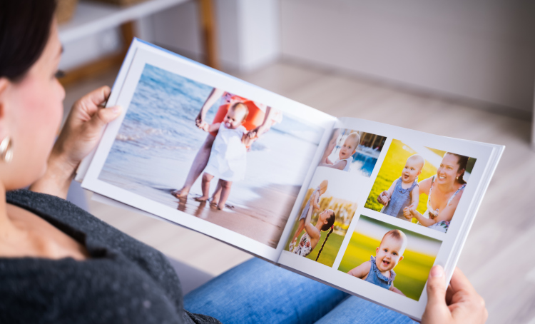 A woman looks at a Photobook with young children