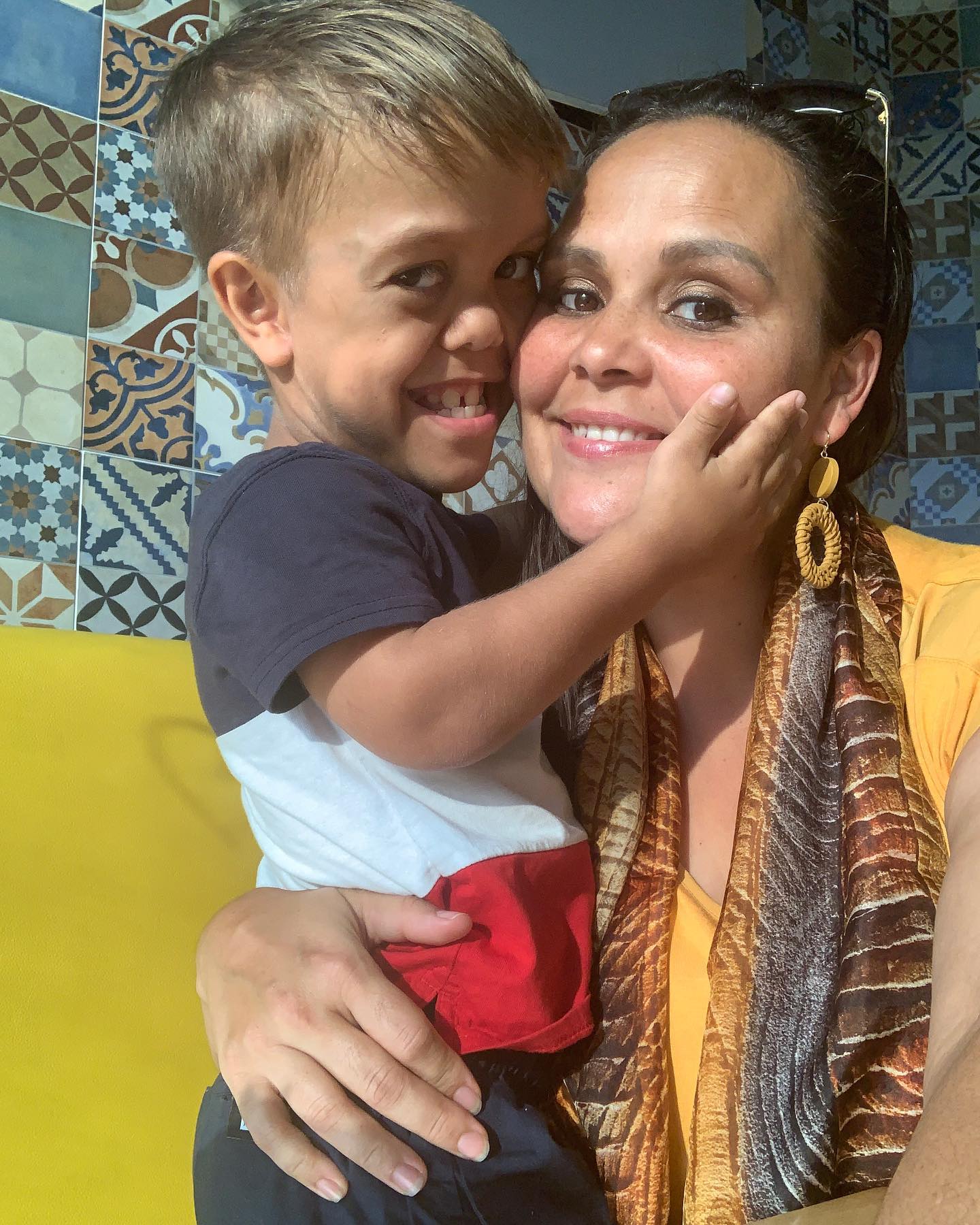 Quaden and his mother Yarraka. An Aboriginal boy with short stature and his mother smiling and hugging. 