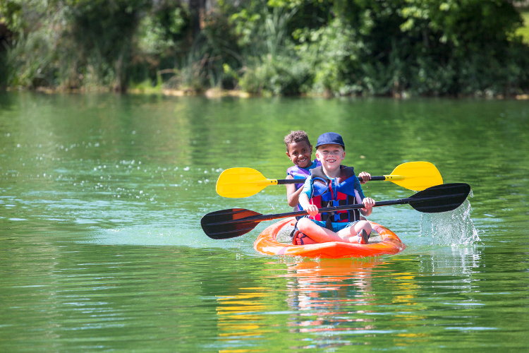 Image of two children rowing on a lake or river.