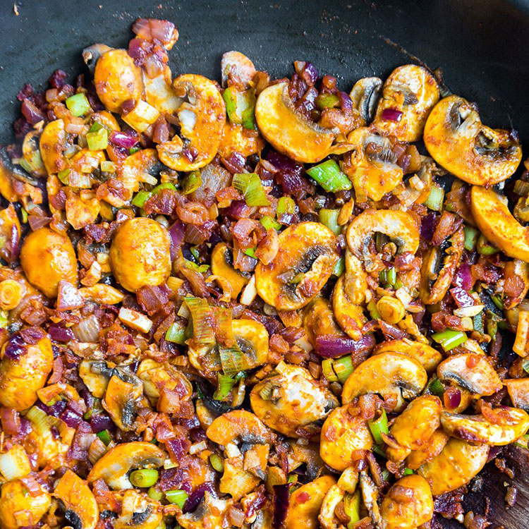 mushrooms, onions and other ingredients coated paprika and tomato in a non-stick pan