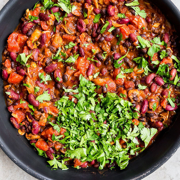 beans, onions, mushrooms, tomatoes with paprika and herbs in a non-stick pan 