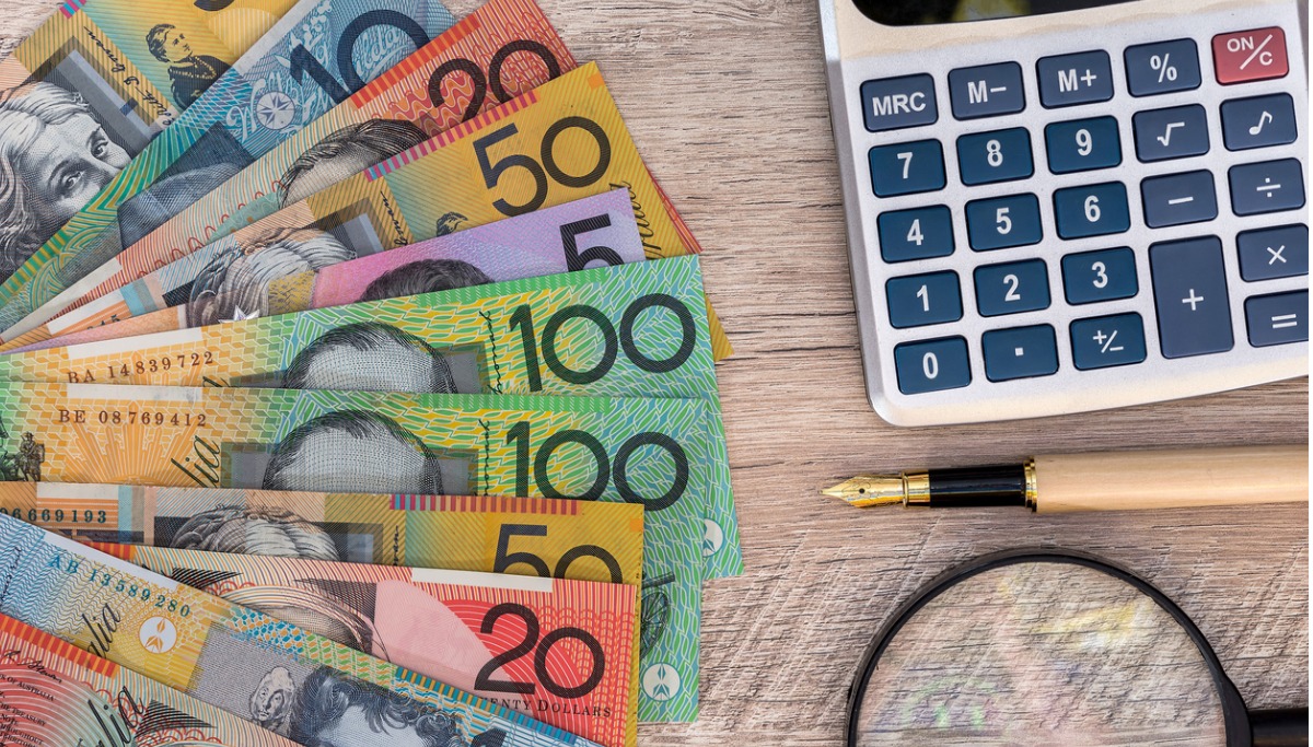 Australian bank notes, a calculator, magnifying glass and pen