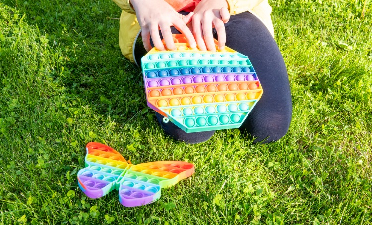 child playing with bright rainbow sensory toys