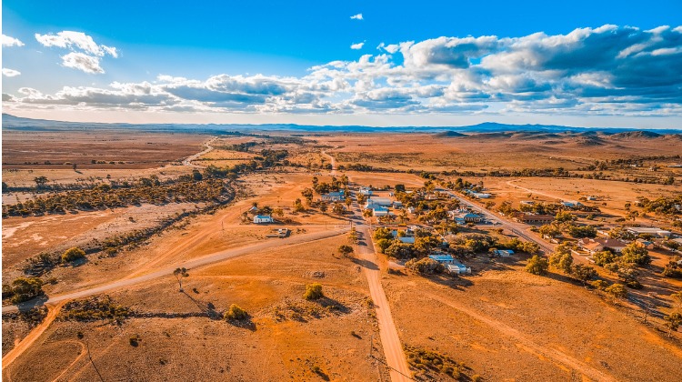 Image of small country town in desert location with blue sky and white clouds.