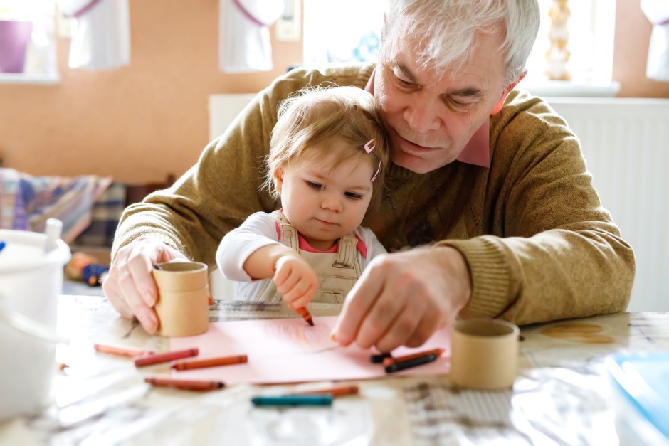 Image of elderly man and little girl colouring in together