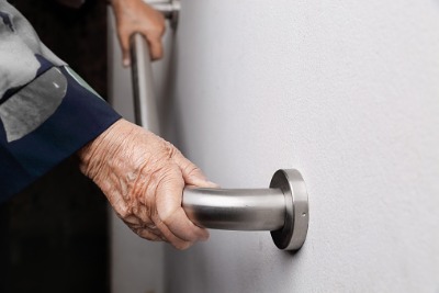 Elderly woman holding onto a grab rail