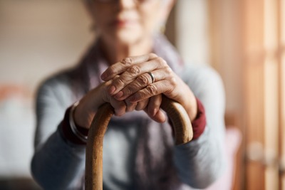 Older woman holding a cane.