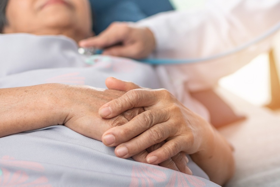 elderly woman in a hospital bed having a medical exam