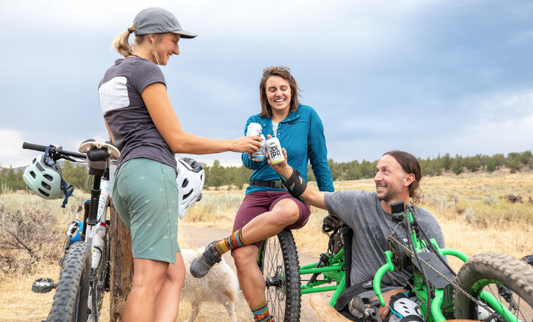 A group of friends, two with mountain bikes and one with a recumbent mountain bike