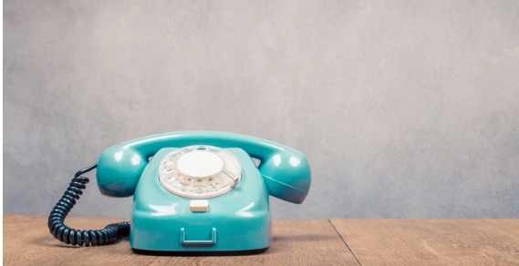 mint green rotary phone on a desk