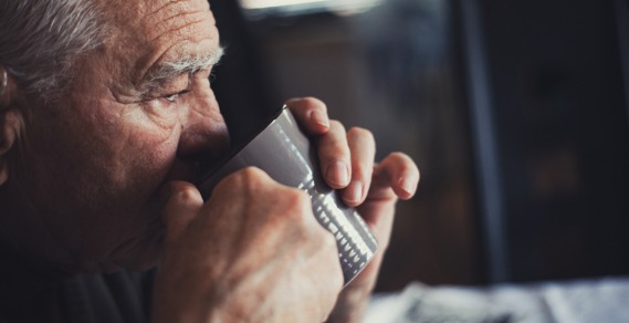 An elderly man drinking coffee