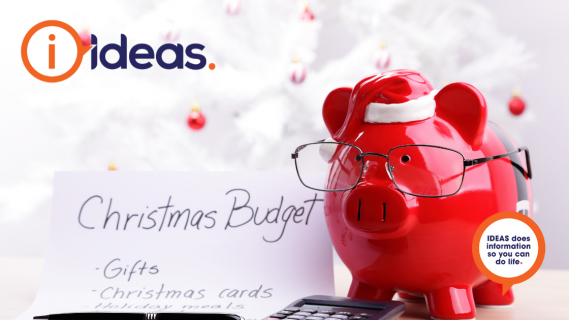 A red piggy bank wears glasses, next to a black calculator and list with "Christmas Budget"