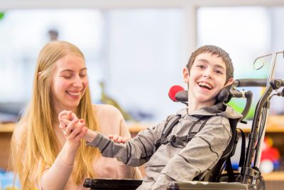 Boy in a wheelchair with a carer