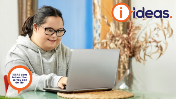 A girl with glasses and dark hair with intellectual disability is using a laptop computer