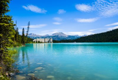An image overlooking a blue lake with mountains in the background and Chateau Lake Louise