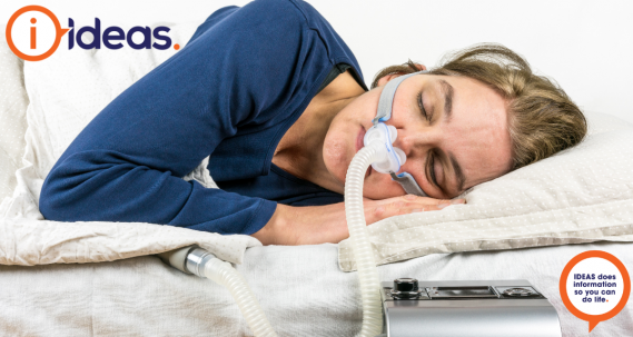 A woman wearing a CPAP machine sleeps.