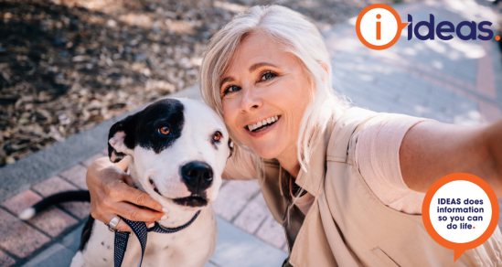 Image of a selfie of a lady and a dog. They are outside and she holds the lead