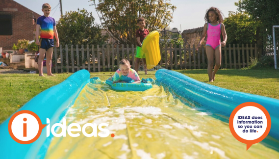 Children playing on and around a slip and slide.